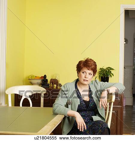 Woman sitting at kitchen table View Large Photo Image Stock Photography - Woman sitting at kitchen table. Fotosearch