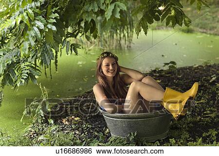 Woman sitting in bucket in garden View Large Photo Image Stock Photograph - Woman sitting in bucket in garden. Fotosearch