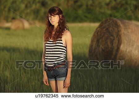Woman standing in grassy field View Large Photo Image Stock Photography - Woman standing in grassy field. Fotosearch