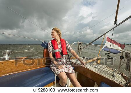Woman steering boat on rocky water View Large Photo Image Stock Image - Woman steering boat on rocky water. Fotosearch
