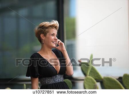 Woman talking on cell phone outdoors View Large Photo Image Stock Image - Woman talking on cell phone outdoors. Fotosearch
