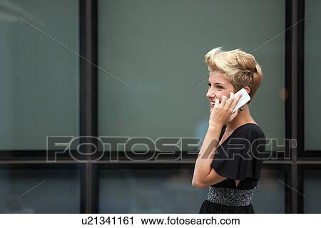 Woman talking on cell phone outdoors View Large Photo Image Stock Image - Woman talking on cell phone outdoors. Fotosearch