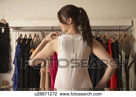 Woman trying on shirt in store View Large Photo Image Stock Image - Woman trying on shirt in store. Fotosearch