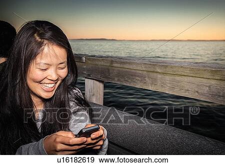 Woman using cell phone outdoors View Large Photo Image Stock Photo - Woman using cell phone outdoors. Fotosearch