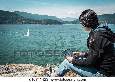 Woman using tablet computer outdoors View Large Photo Image Stock Image - Woman using tablet computer outdoors. Fotosearch