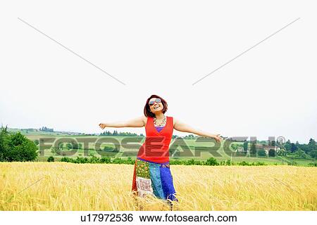 Woman walking in tall grass View Large Photo Image Stock Photograph - Woman walking in tall grass. Fotosearch