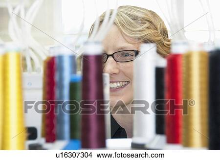 Worker examining spools of thread View Large Photo Image Picture - Worker examining spools of thread. Fotosearch