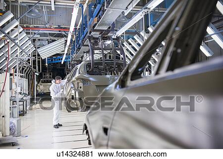 Worker inspecting car body in car factory View Large Photo Image Stock Image - Worker inspecting car body in car factory. Fotosearch
