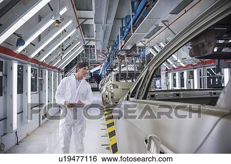 Worker inspecting car body in car factory View Large Photo Image Stock Photograph - Worker inspecting car body in car factory. Fotosearch