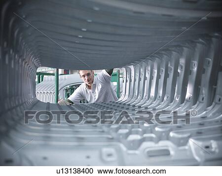 Worker inspecting car body pressings in car factory View Large Photo Image Stock Image - Worker inspecting car body pressings in car factory. Fotosearch