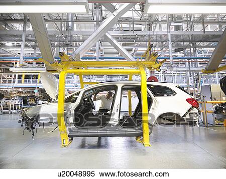 Stock Photography - Worker inspecting inside car in car factory. Fotosearch
