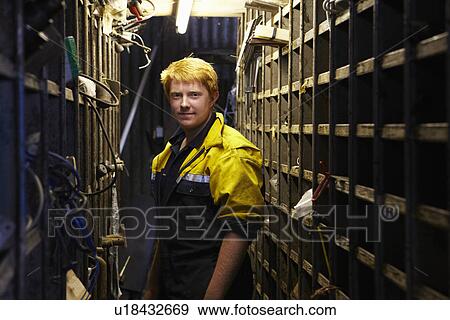 Stock Photo - Worker standing in warehouse. Fotosearch