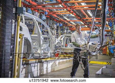 Worker with car bodies and machinery on production line in car factory View Large Photo Image Stock Image - Worker with car bodies and machinery on production line in car factory. Fotosearch