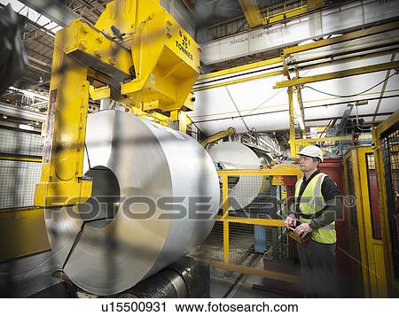 Worker with steel rolls in car factory View Large Photo Image Stock Image - Worker with steel rolls in car factory. Fotosearch