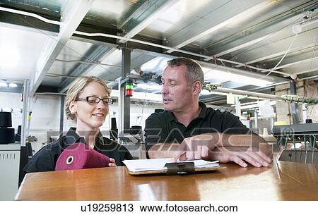 Workers talking in garment factory View Large Photo Image Stock Image - Workers talking in garment factory. Fotosearch