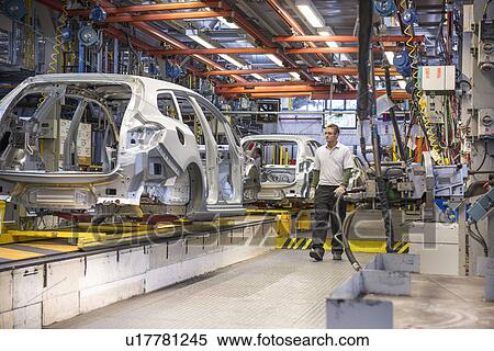 Stock Photography - Workers with car bodies on production line in car factory. Fotosearch
