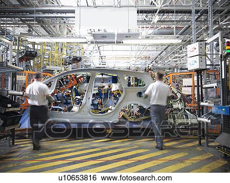 Workers with car body part in welding jig in car factory View Large Photo Image Stock Photograph - Workers with car body part in welding jig in car factory. Fotosearch