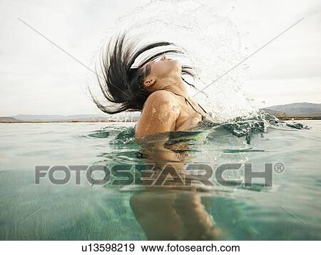 Attractive young woman emerging from swimming pool View Large Photo Image Stock Photo - Attractive young woman emerging from swimming pool. Fotosearch