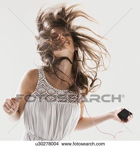 Beautiful woman dancing with portable music player in hand View Large Photo Image Picture - Beautiful woman dancing with portable music player in hand. Fotosearch