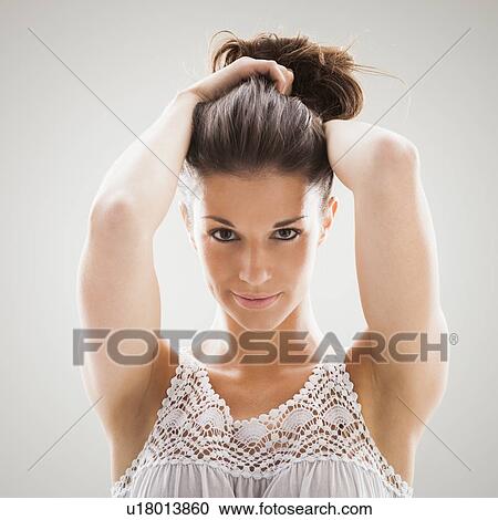 Beautiful woman holding hair up for camera View Large Photo Image Stock Image - Beautiful woman holding hair up for camera. Fotosearch