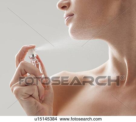 Beautiful woman spraying perfume on her neck View Large Photo Image Picture - Beautiful woman spraying perfume on her neck. Fotosearch