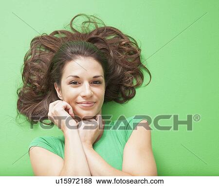 Beauty shot of girl laying on green background View Large Photo Image Stock Photo - Beauty shot of girl laying on green background. Fotosearch