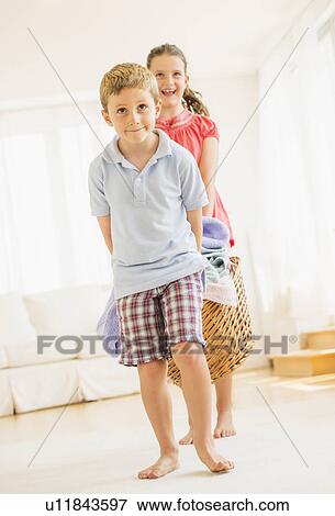 Stock Photo - Boy (6-7) and girl (8-9) doing laundry. Fotosearch