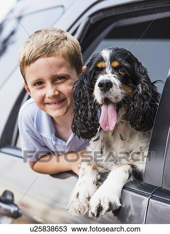 Boy (6-7) and his dog peeking from car window View Large Photo Image Stock Image - Boy (6-7) and his dog peeking from car window. Fotosearch