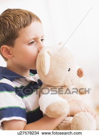 Boy (6-7) hugging his teddy-bear View Large Photo Image Picture - Boy (6-7) hugging his teddy-bear. Fotosearch