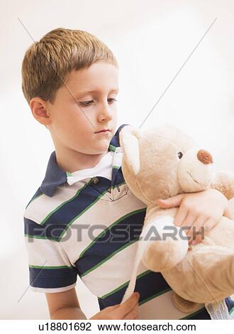Boy (6-7) hugging his teddy-bear View Large Photo Image Stock Image - Boy (6-7) hugging his teddy-bear. Fotosearch