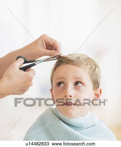 Stock Image - Boy (6-7) undergoing haircut. Fotosearch