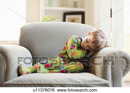 Boy in his pijamas sleeping on armchair View Large Photo Image Stock Photograph - Boy in his pijamas sleeping on armchair. Fotosearch