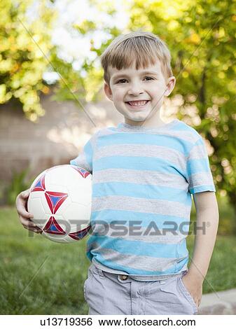 Boy smiling and holding soccer ball View Large Photo Image Stock Photograph - Boy smiling and holding soccer ball. Fotosearch