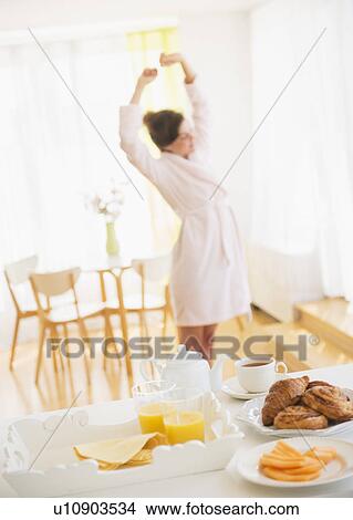 Breakfast scene with woman in white robe stretching View Large Photo Image Picture - Breakfast scene with woman in white robe stretching. Fotosearch