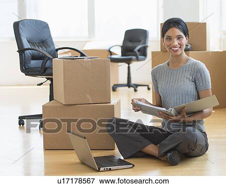 Businesswoman reading documents in new office View Large Photo Image Stock Photo - Businesswoman reading documents in new office. Fotosearch
