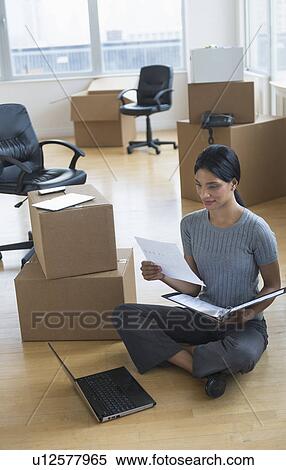 Businesswoman reading documents in new office View Large Photo Image Stock Photography - Businesswoman reading documents in new office. Fotosearch