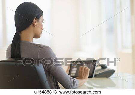 Businesswoman using digital tablet in office View Large Photo Image Stock Image - Businesswoman using digital tablet in office. Fotosearch