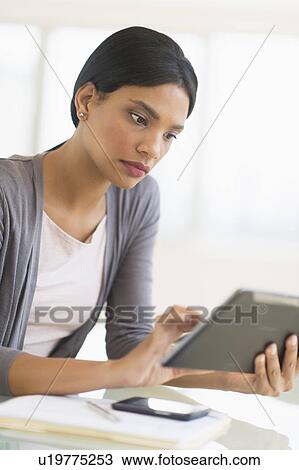 Businesswoman using digital tablet in office View Large Photo Image Stock Image - Businesswoman using digital tablet in office. Fotosearch