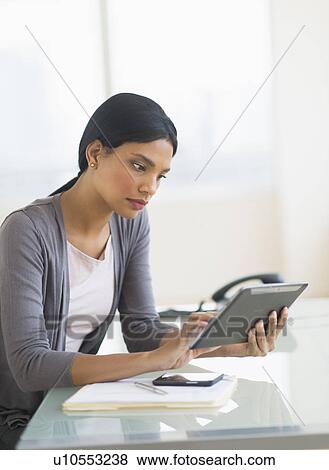 Stock Photo - Businesswoman using digital tablet in office. Fotosearch