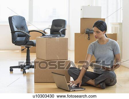 Businesswoman using laptop in new office View Large Photo Image Stock Image - Businesswoman using laptop in new office. Fotosearch