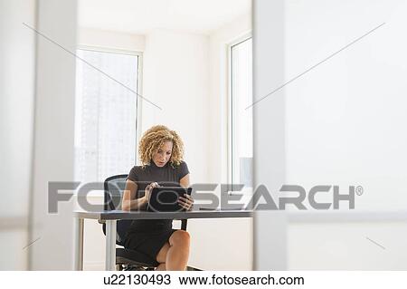 Businesswoman working at desk in office View Large Photo Image Stock Image - Businesswoman working at desk in office. Fotosearch