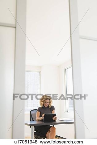Businesswoman working at desk in office View Large Photo Image Stock Photo - Businesswoman working at desk in office. Fotosearch