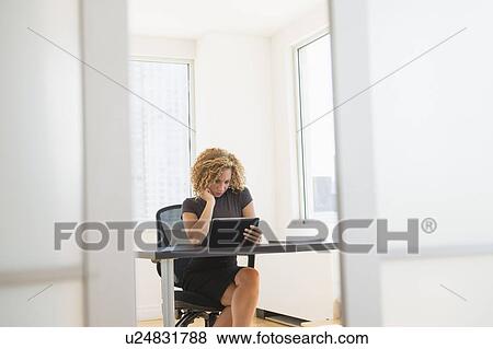 Businesswoman working at desk in office View Large Photo Image Stock Photo - Businesswoman working at desk in office. Fotosearch