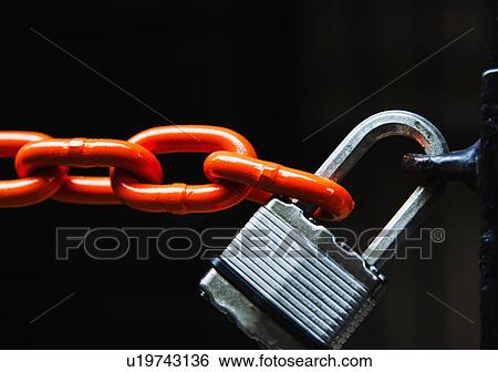 Stock Photograph - Chain with padlock on black background, studio shot. Fotosearch