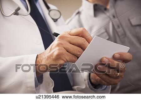Stock Photograph - Close-up of doctor writing prescription for patient. Fotosearch