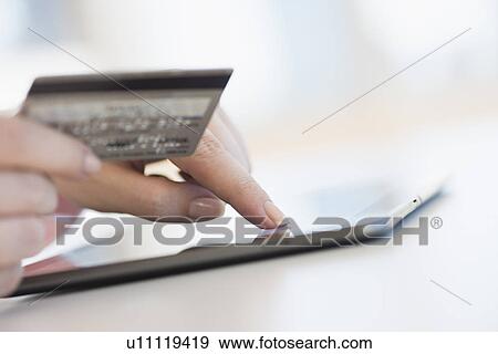 Stock Photo - Close up of woman's hand doing online banking with laptop. Fotosearch