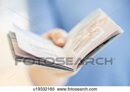 Close up of woman's hand holding open passport View Large Photo Image Stock Photography - Close up of woman's hand holding open passport. Fotosearch