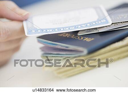 Picture - Close up of woman's hand holding Social Security Card. Fotosearch