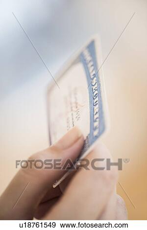 Stock Photo - Close up of woman's hand holding social security card. Fotosearch