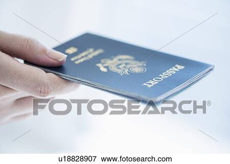 Stock Photo - Close up of woman's hand holding passport. Fotosearch